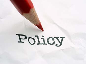 Policy on paper with pencil pointing at it