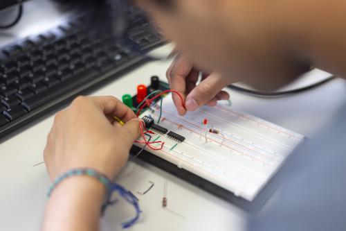 A student works on a circuitboard. 