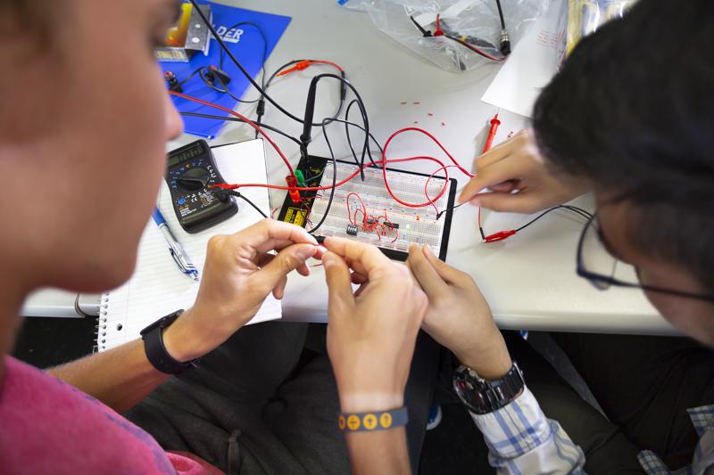 Students work on a circuitboard in an electrical engineering class.